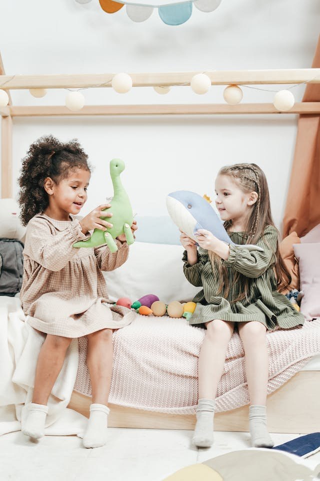 Two children playing with stuffed animal toys