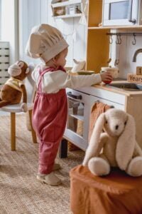 Toddler playing with a toy kitchen set